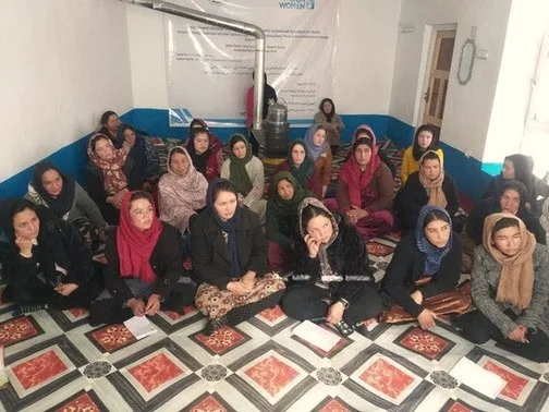 A large group of women seated in rows during a training session.